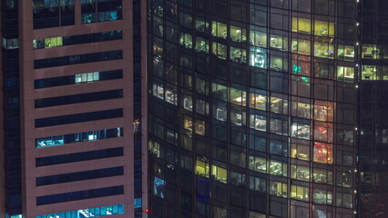 Windows in high-rise building exterior in the late evening with interior lights on timelapse