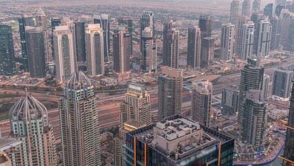 Obraz premium JLT and Dubai marina skyscrapers near Sheikh Zayed Road aerial day to night timelapse. Residential buildings