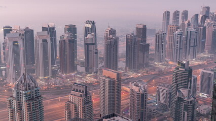 JLT skyscrapers and marina towers near Sheikh Zayed Road aerial night to day timelapse. Residential buildings