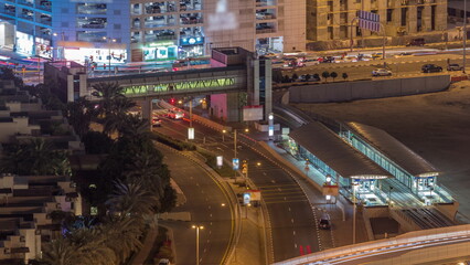 Fototapeta na wymiar Tram station in Dubai Marina with footbridge aerial night timelapse