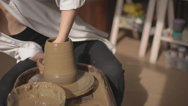 a man in a workshop works on a potter's wheel