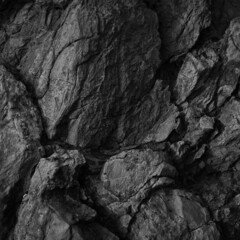 Black white rock texture. Rough mountain surface. Close-up. Dark volumetric stone background with space for design. Crumbled. Weathered. 