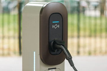 Une station de charge pour voiture électrique en ville. Le connecteur est inséré et le fil de rechargement est branché. © Gautier Normand