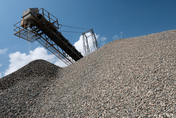 mountain of crushed and washed stone in a mining production of concrete aggregates