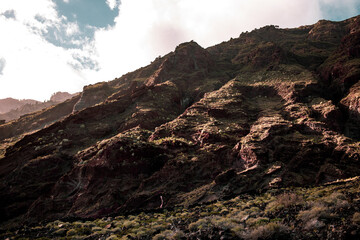 Island vulcanic mountain with stones, rocks, cliffs, sky.