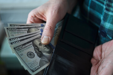 man putting money in wallet