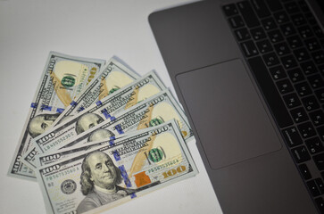 Money lies near the laptop, the concept of remote earnings