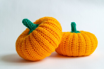 two knitted pumpkins on a white background