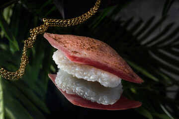 Sushi and rolls on a dark mirror dish.