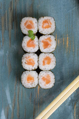 Multicolored sushi and rolls in a gray dish in a restaurant.