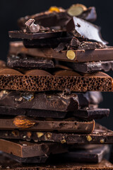 Bar of Chocolate tower pieces. Hazelnut and almond dark chunks of broken chocolate. Sweet food photo concept.