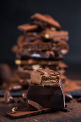 Bar of Chocolate tower pieces. Hazelnut and almond dark chunks of broken chocolate. Sweet food photo concept.