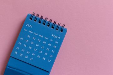 Desktop mini calendar for August 2022 on a pink background.