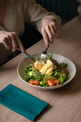 The process of cutting a poached egg in a vegetable salad
