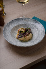 Baked octopus with garnish and microgreens