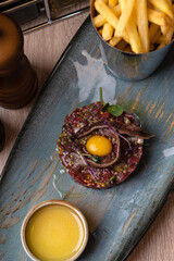 Tartar with quail egg on a gray plate