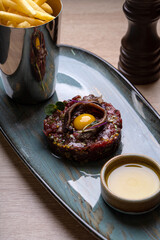Tartar with quail egg on a gray plate