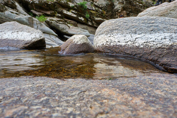 Natural geological rock formation, water flow and rocks shaped by flow water.