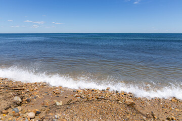 a small wave hitting a rocky beach