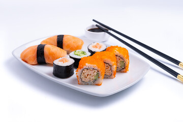 Sushi plate on white background. Makizushi. Delicious sushi rolls on white plate with chopsticks...