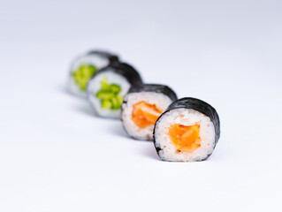 Four maki rolls with salmon and cucumber isolated on white background.