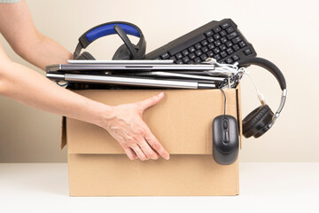 Woman hands holding cardboard box full old used computers, phones, tablets, gadget devices for...