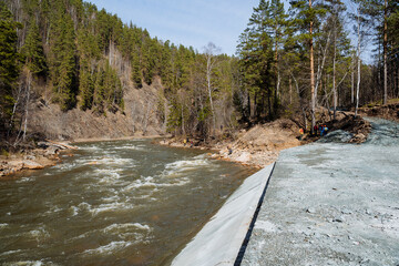 A concrete structure on the bank of a mountain river, a fence to protect the shore from...