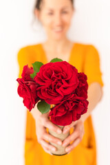 The girl holds red roses in her hands