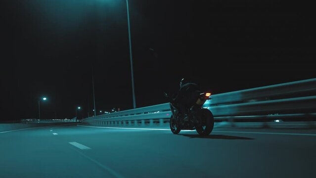 A man rides a sports motorcycle on a night track