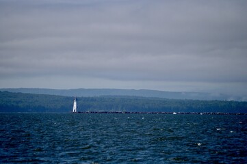 Obraz premium Moody restful Lake Superior near Ashland Wisconsin with a lighthouse and water break in the distance.