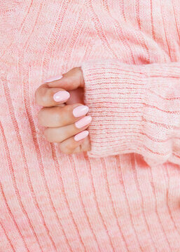 pink manicure on the texture of a pink sweater, hand care, pastel colors of manicure, comfort, 