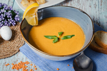 Lentil soup in a blue dish with lemon. Top view