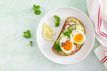 Toast with boiled egg, radish, cucumber and avocado pate. Top view - Powered by Adobe