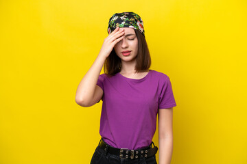 Young Ukrainian woman isolated on yellow background with headache