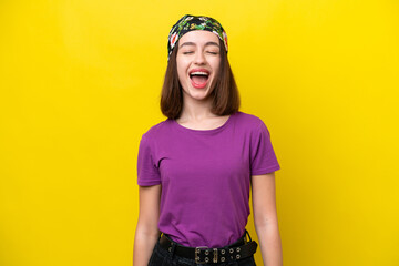 Young Ukrainian woman isolated on yellow background shouting to the front with mouth wide open