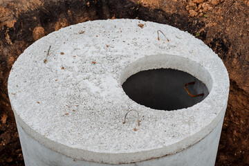 Concrete well sewerage, round-shaped lid made of cement, septic tank for dirty water, installation of concrete rings,