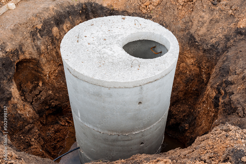 Canvas Prints A well made of concrete, a pit for sewerage, a construction site, a connection of communications to the house, the gray color of cement, a round sewer hatch.