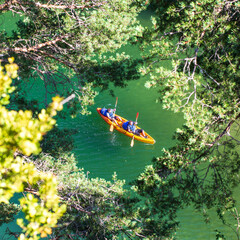 Orange canoe-kayak seen through the trees