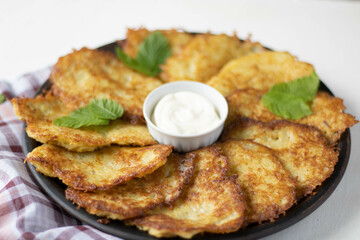 potato pancakes with sour cream on wooden table