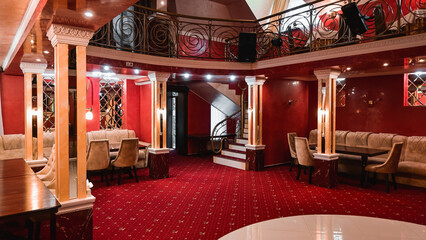 stylish modern premium restaurant. restaurant interior. columns in the center of the restaurant. upholstered furniture and red carpets.