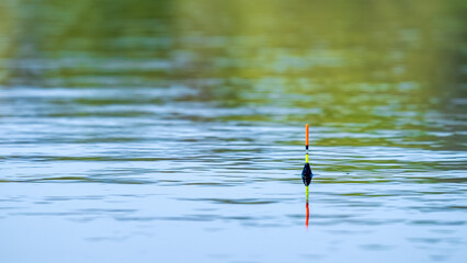 Yellow-orange fishing float on the surface of the water
