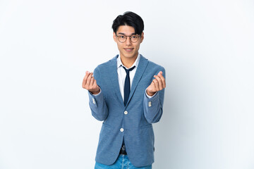 Young Chinese business man isolated on white background making money gesture