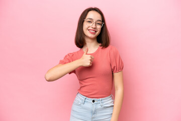 Young Ukrainian woman isolated on pink background giving a thumbs up gesture