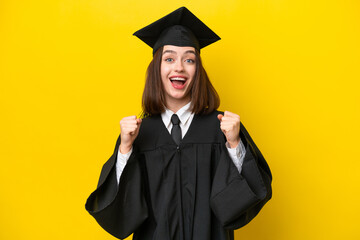 Young university graduate Ukrainian woman isolated on yellow background celebrating a victory in...