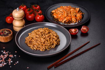 Thai noodle and chicken plate on a black concrete background with Chinese chopsticks and copy space