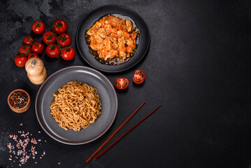 Thai noodle and chicken plate on a black concrete background with Chinese chopsticks and copy space