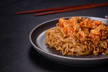 Thai noodle and chicken plate on a black concrete background with Chinese chopsticks and copy space