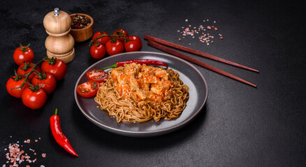 Thai noodle and chicken plate on a black concrete background with Chinese chopsticks and copy space