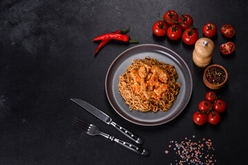 Thai noodle and chicken plate on a black concrete background with Chinese chopsticks and copy space