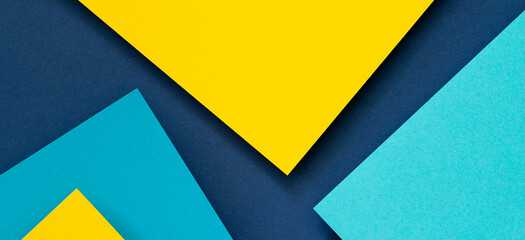Abstract color papers geometry flat lay composition banner background with blue and yellow tones